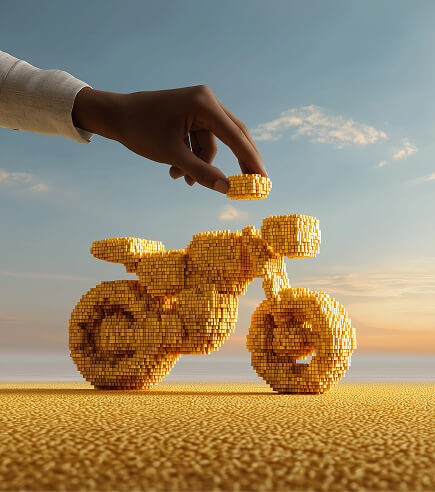 Mão adicionando peça a uma moto montada com pecinhas douradas, horizonte ao fundo.